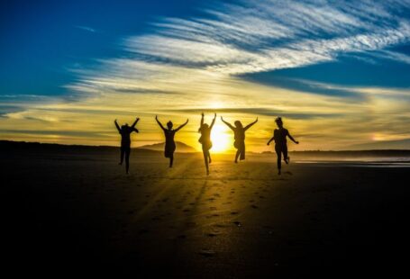 Extracurricular Success - people jumping on shore front of golden hour