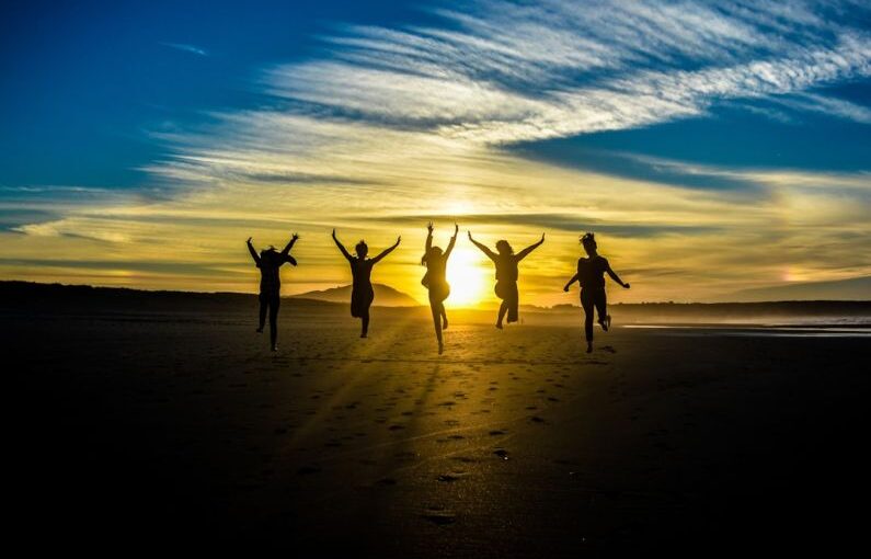 Extracurricular Success - people jumping on shore front of golden hour