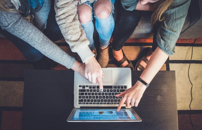 Generational Learning - three person pointing the silver laptop computer