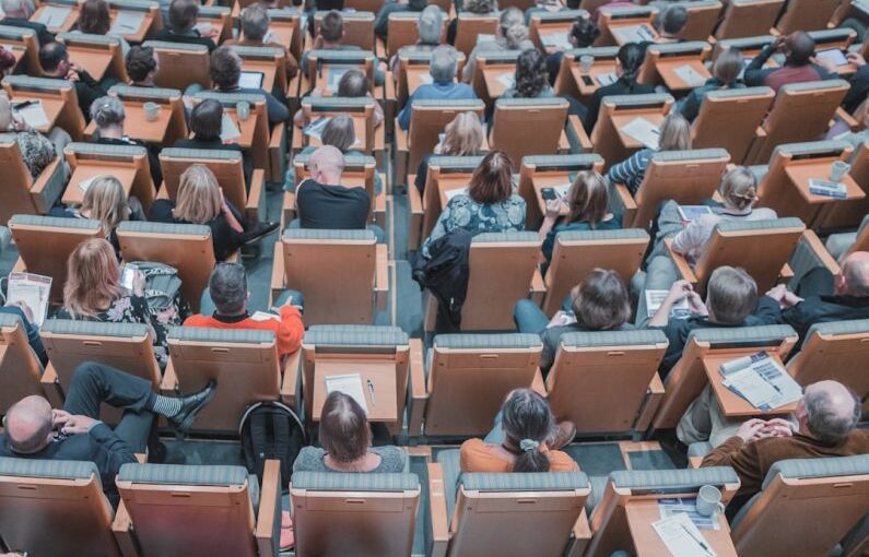 Hybrid Education - high-angle photography of group of people sitting at chairs