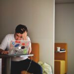 Student Debt - man wearing white top using MacBook
