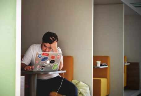 Student Debt - man wearing white top using MacBook