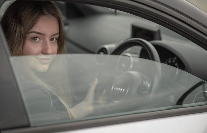 Adult Learners - a woman sitting in a car holding a steering wheel