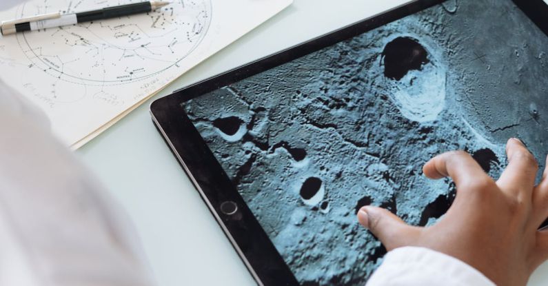 Project Learning - Crop astrophysicist exploring surface of moon while using tablet in university