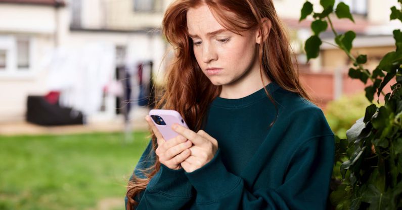 Digital Divide - Redhead Woman Standing under Tree Using Phone