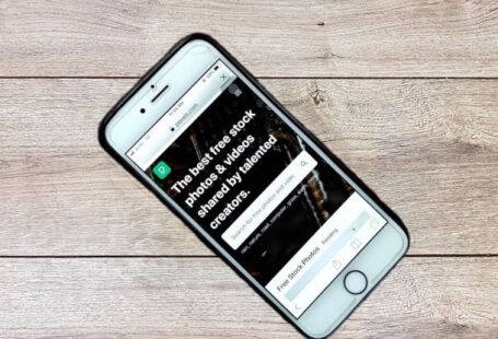 Global Network - Top view contemporary mobile phone with opened website on screen placed on wooden table