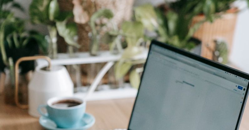 Green Jobs - Crop anonymous freelancer browsing modern netbook while sitting at table in light room with many green potted plants at home