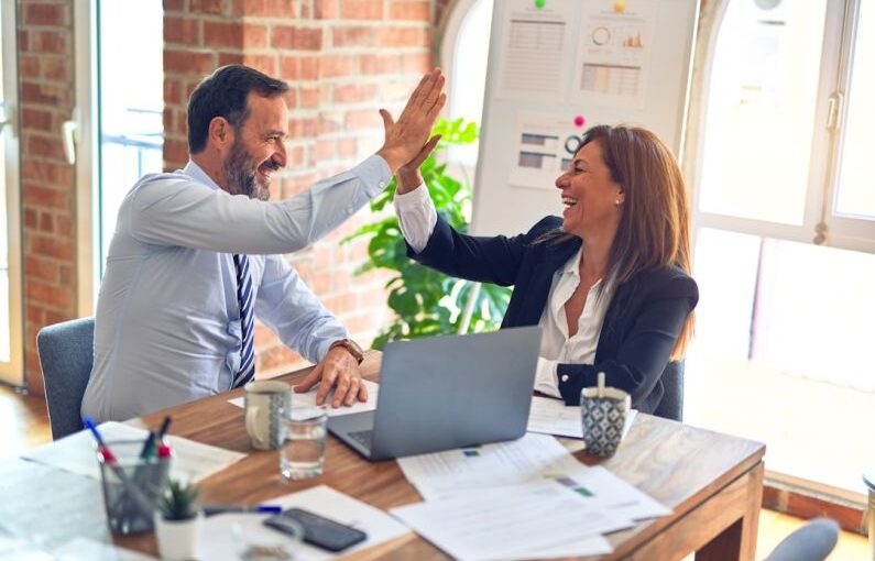 Success Story - man in white dress shirt sitting beside woman in black long sleeve shirt