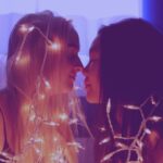 Non-traditional Student - two woman facing each other with string lights